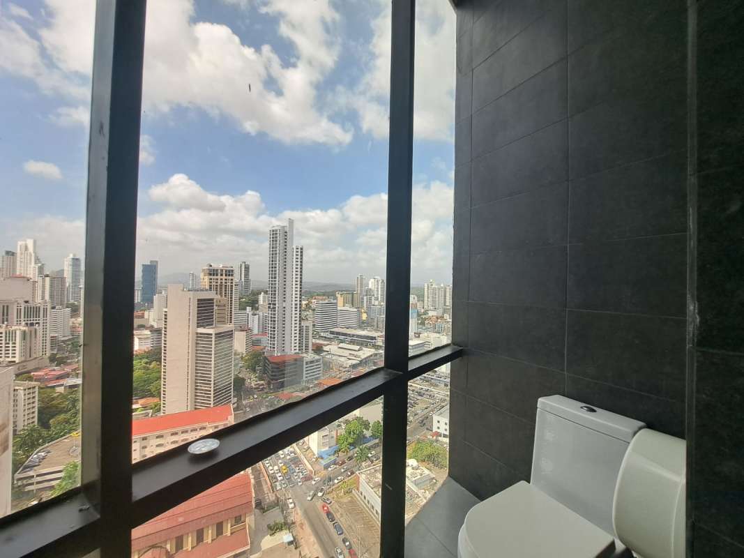 Modern commercial bath with floor-to-ceiling window city skyline Torre Generali Obarrio Panama