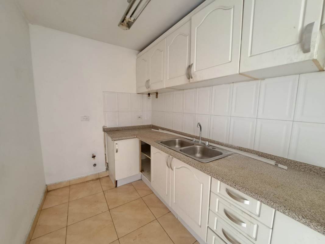 Compact kitchen with white cabinets, L-shaped counter and double sink PH Sunset Place Via Porras Panama City