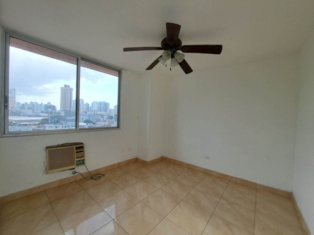 Bedroom with ceiling fan, tiled floor and large window city view in PH Sunset Place Panama