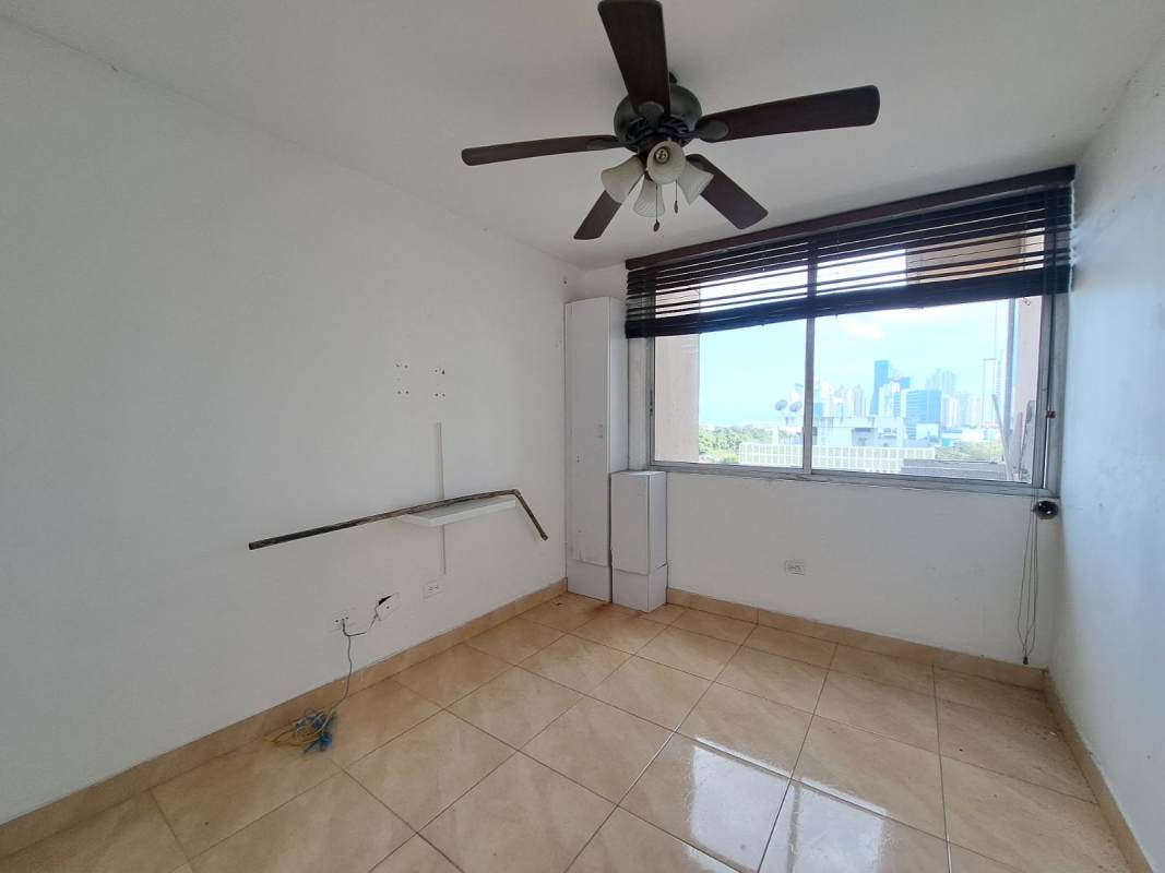 Bedroom with city skyline view, ceiling fan, window AC, tiled floor in PH Sunset Place, San Francisco Panama