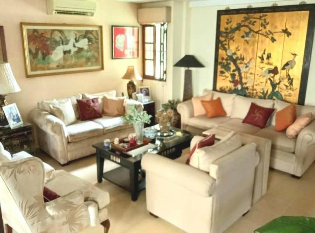 Traditional living room with Asian-inspired art, cream sofas and decor in Panama 3-level house
