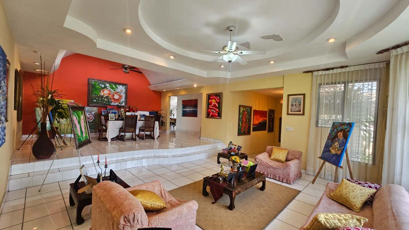Large kitchen with white cabinetry, island with glass block, ceramic floors and abundant natural light in Los Angeles Betania Panama