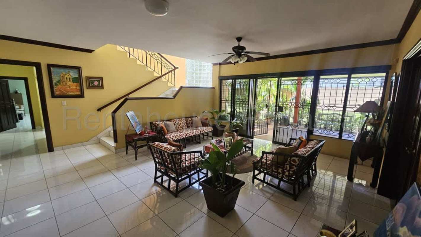 Open layout living and dining area with tall ceilings, art displays, tile floors, Los Angeles Betania Panama