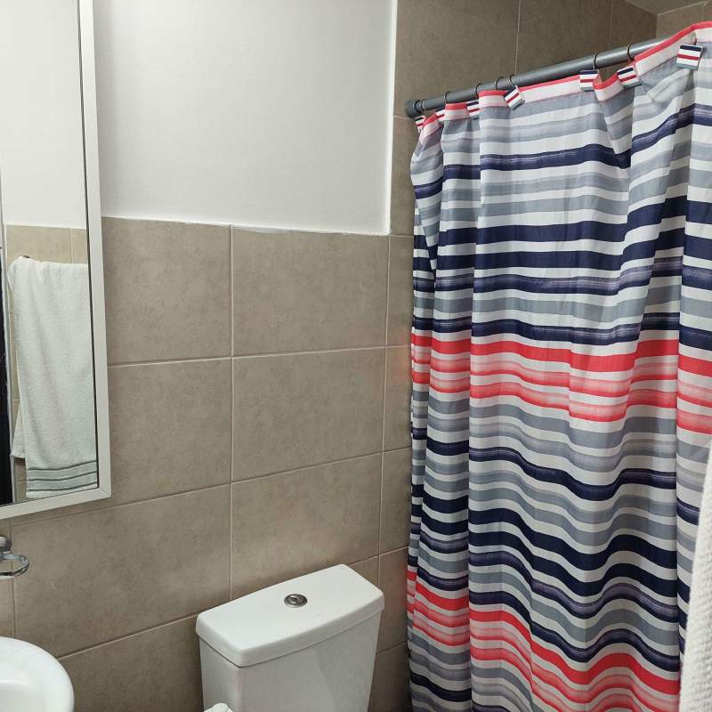 Modern bathroom with tiled walls, shower and vanity in apartment near Parque Omar Panama