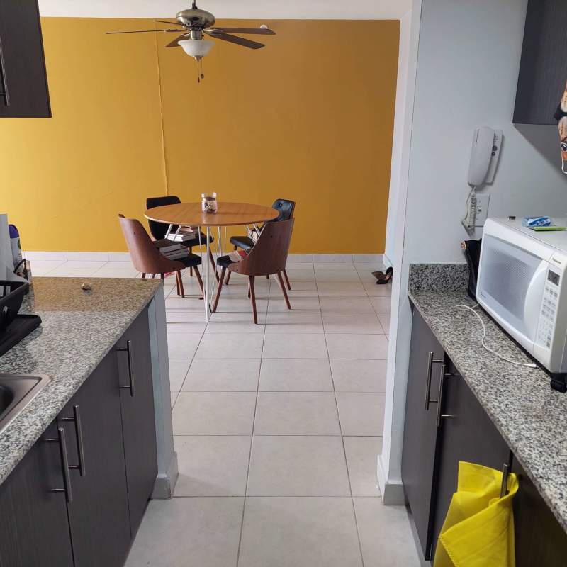 Bathroom with striped shower curtain vanity and tiled walls in Panama apartment near Parque Omar