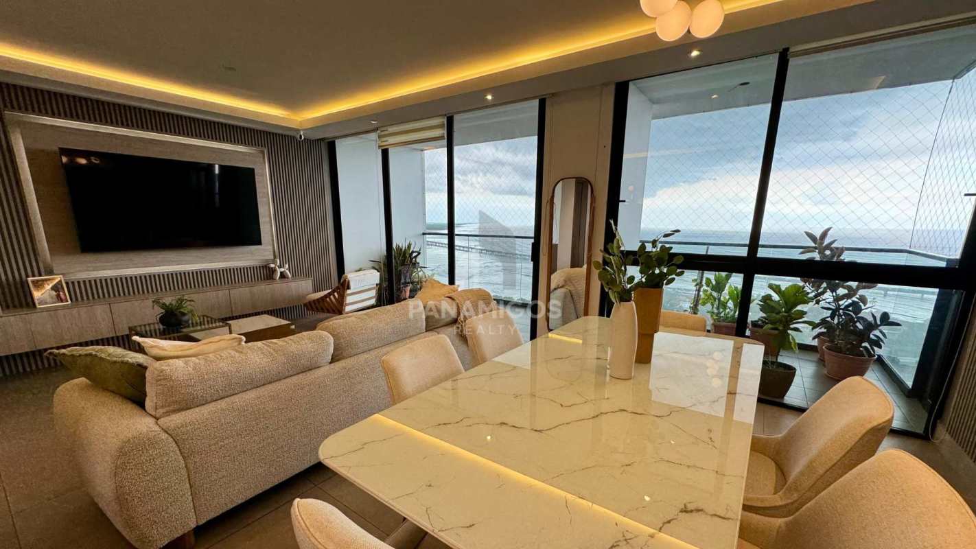 Open-plan living and dining area with ocean view balcony at Victory Wellness Tower Panama