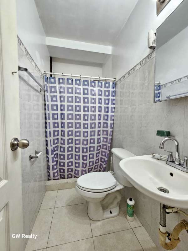 Compact bathroom with sink, shower, white tiles PH Torres del Rey Hato Pintado Panama City