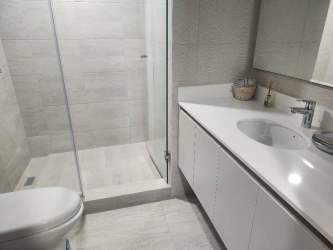 Modern bathroom with glass shower enclosure and contemporary fixtures in Parterre Panama Pacifico condo