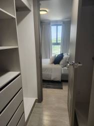 Master bedroom with walk-in closet and large window in brand new Parterre Panama Pacifico condo