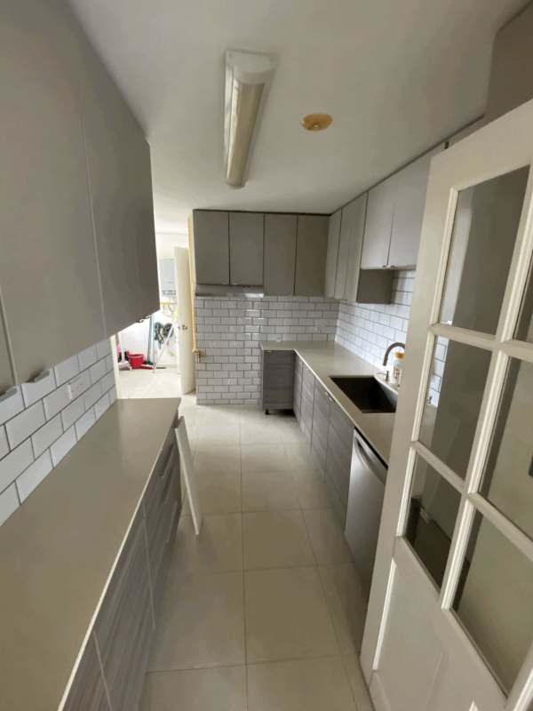 Galley kitchen with grey cabinets and subway tile backsplash PH Villa de las Fuentes Panama