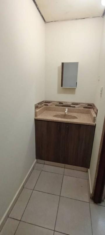 Small bathroom with vanity sink, mirror and tiled walls in rental house at Altos del Angel Nuevo Tocumen Panama