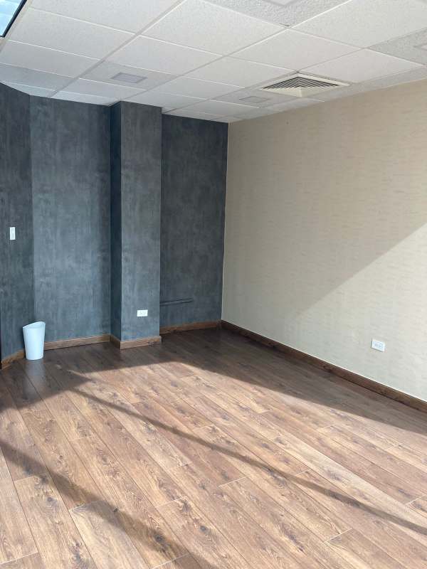 Traditional style lounge with wood floors, glass tables, striped sofa, and ornate decor inside Plaza Obarrio Panama City