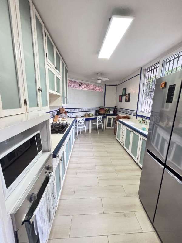 Kitchen with blue tile accents, window, stainless appliances and eating area Bella Vista Panama