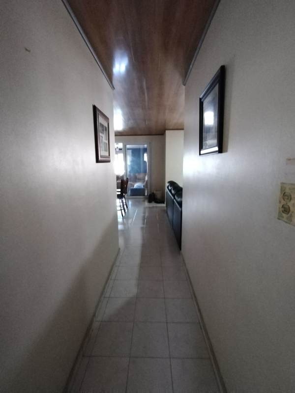 Open kitchen with tiled counters, island and modern lighting in Rufina Alfaro house Panama