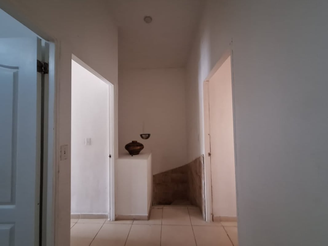 Simple white hallway with tile floor and niche decor inside duplex PH Villas del Naranjal Panama