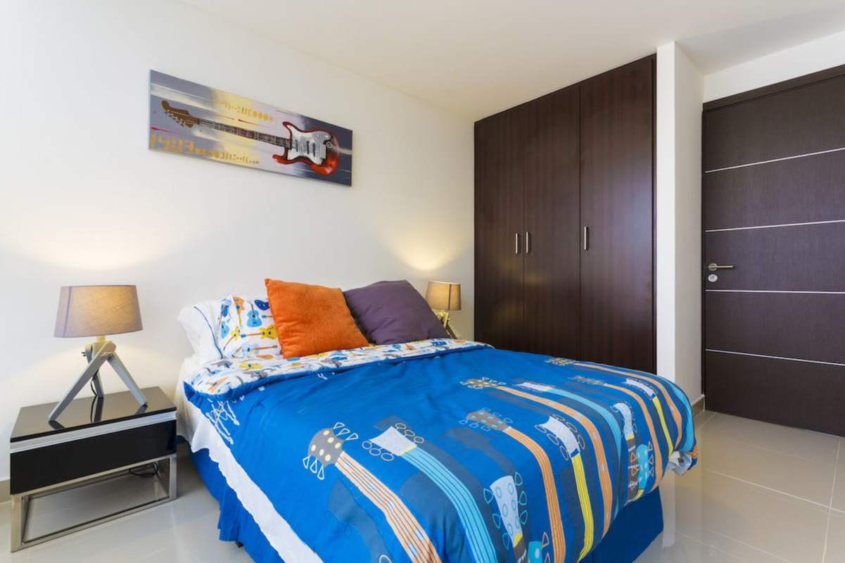Modern bedroom with blue bedding and wardrobe, Portofino Towers Panama City