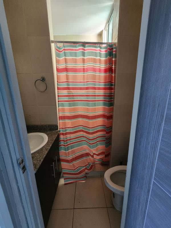 Compact bathroom with granite sink and striped shower curtain PH Lefevre Park Panama