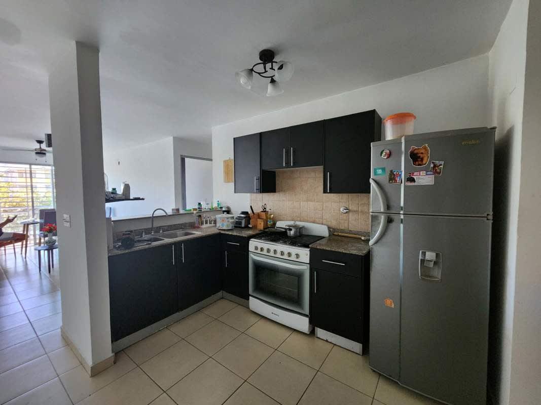 Kitchen with black cabinets, granite countertop, appliances inside PH Lefevre Park Panama