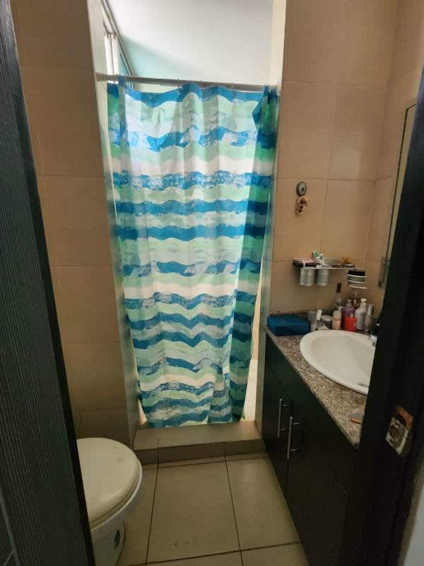 Compact bathroom with granite sink and patterned shower curtain Panama apartment