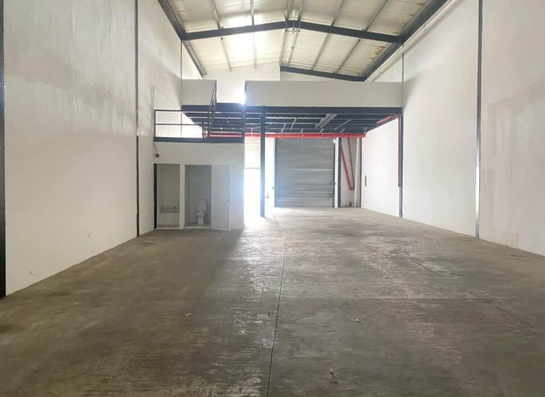 Warehouse interior with mezzanine, concrete floors and large roller shutter in Panama City