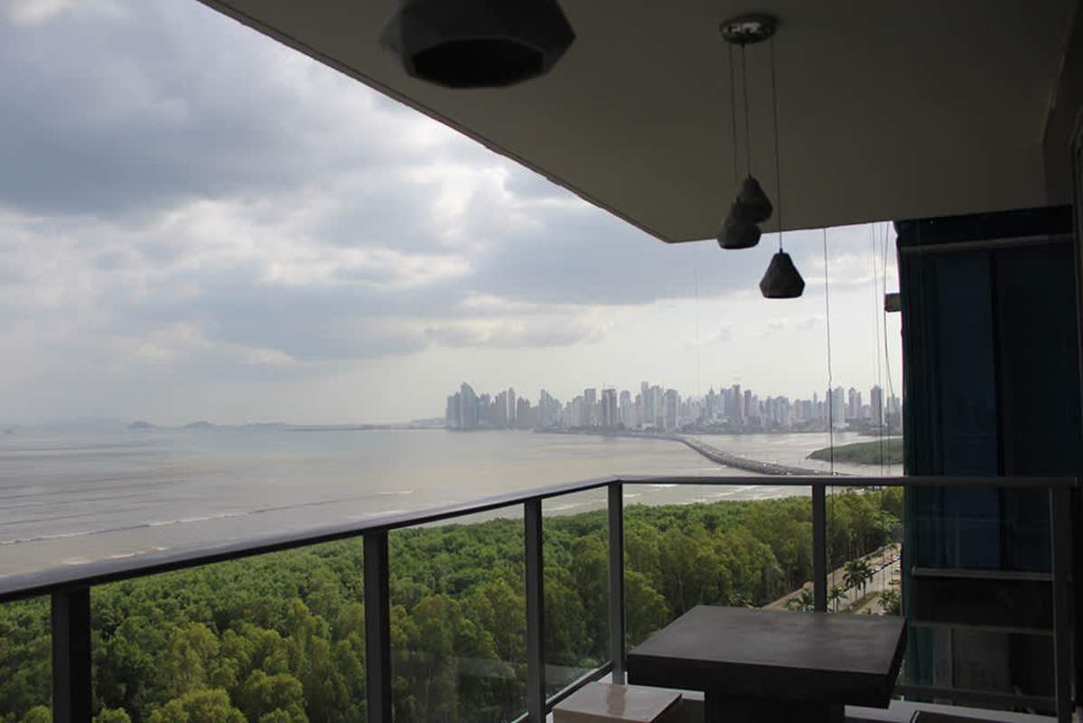 Bright bedroom featuring full glass windows with ocean and golf course views PH Ocean House Panama