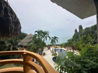 Balcony overlooking lush pool area and ocean at Punta Roca beachfront estate Panama