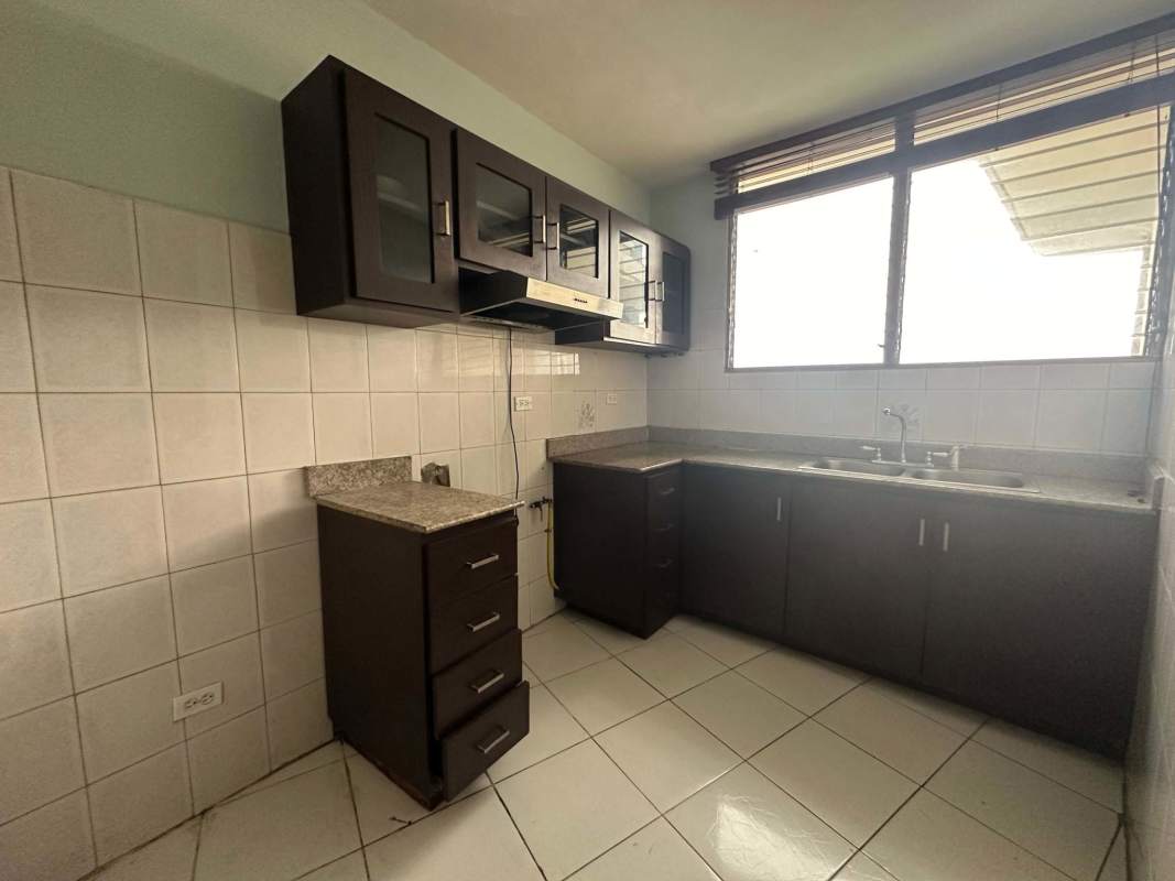 Dark wood cabinetry and granite countertops in apartment kitchen Betania Panama