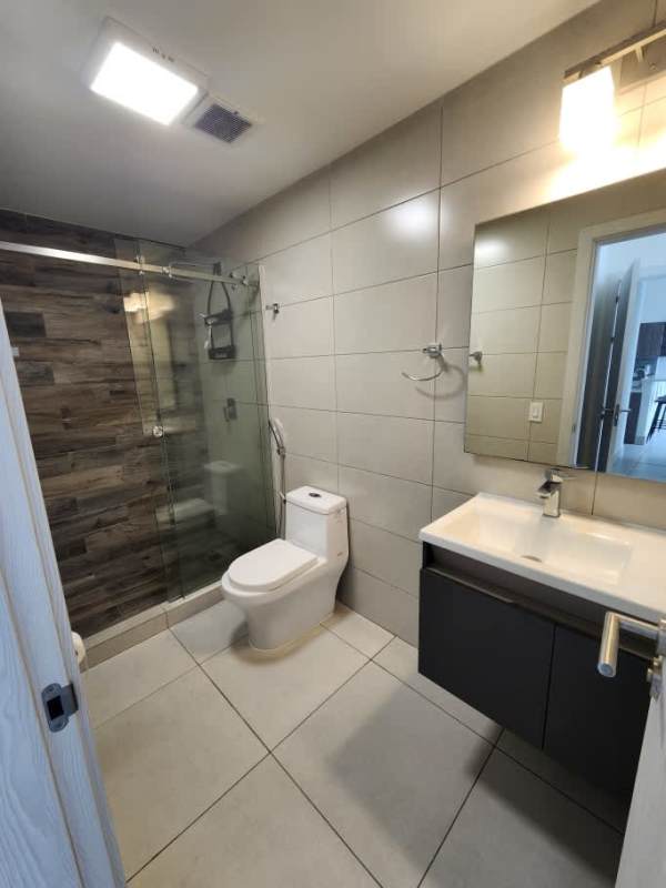 Bathroom with glass-enclosed shower wood accent tiles PH Coco Place rental Panama