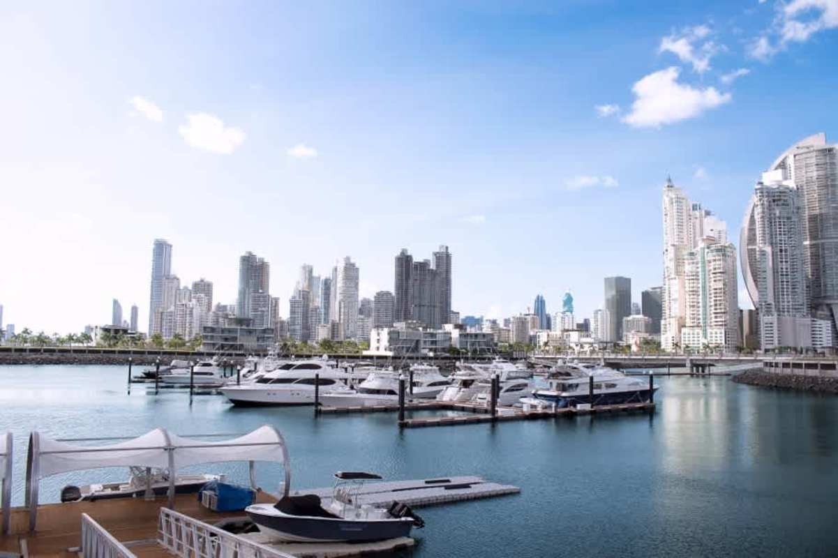 City skyline behind waterfront land at Ocean Reef Panama with yachts and marina visible