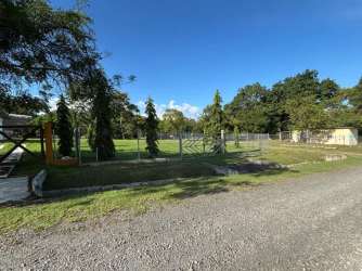 Gated rural lot with large grassy yard, trees, and mountain views at Hacienda La Florenciana