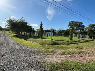 Gravel road and fenced property with lawn and small building Hacienda La Florenciana Las Uvas Panama
