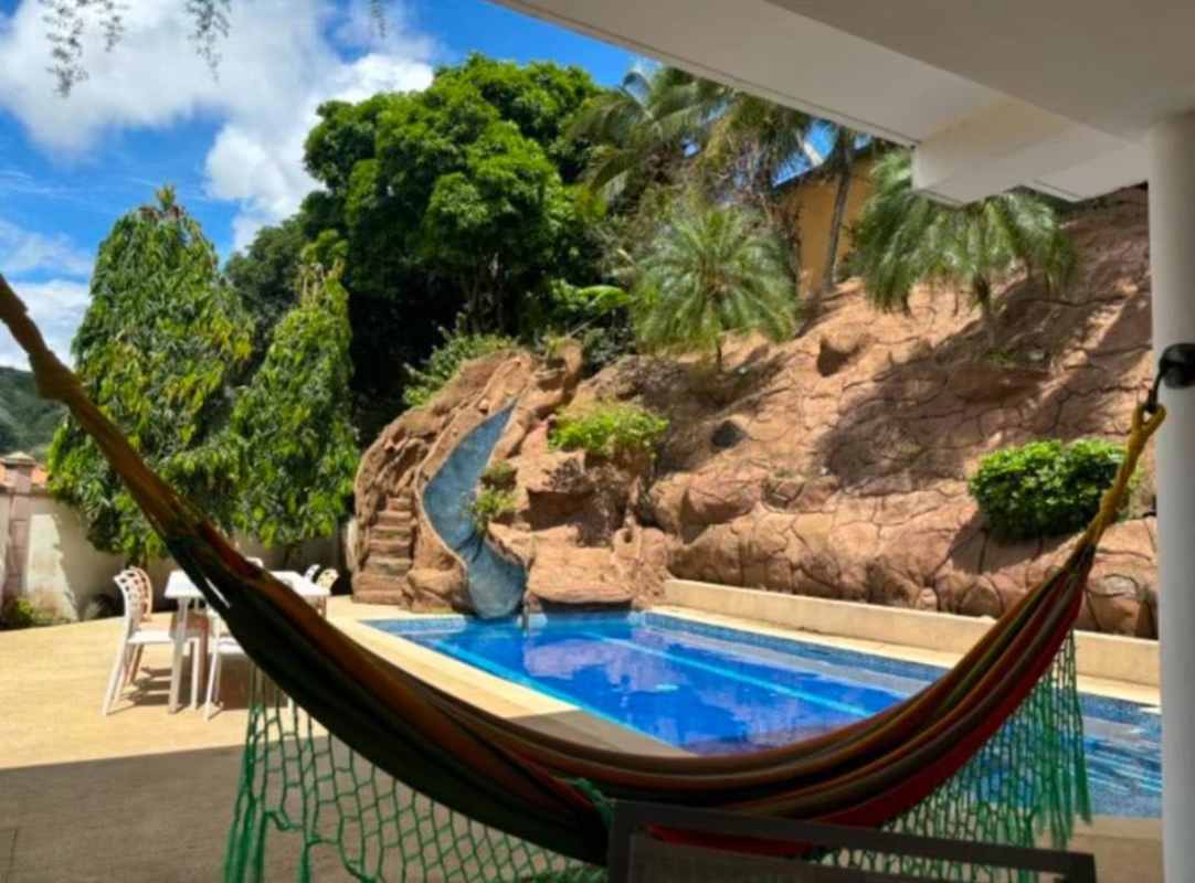 Backyard tropical pool with waterfall, slide, lush landscaping at Fuente del Fresno Condado del Rey