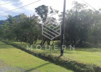 Grassy terrain with mountain backdrop and gravel road access in El Valle Panama