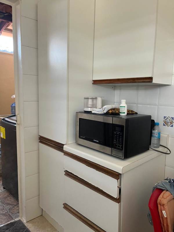 Functional kitchen with granite counters, stove and white cabinets in Brisas del Golf