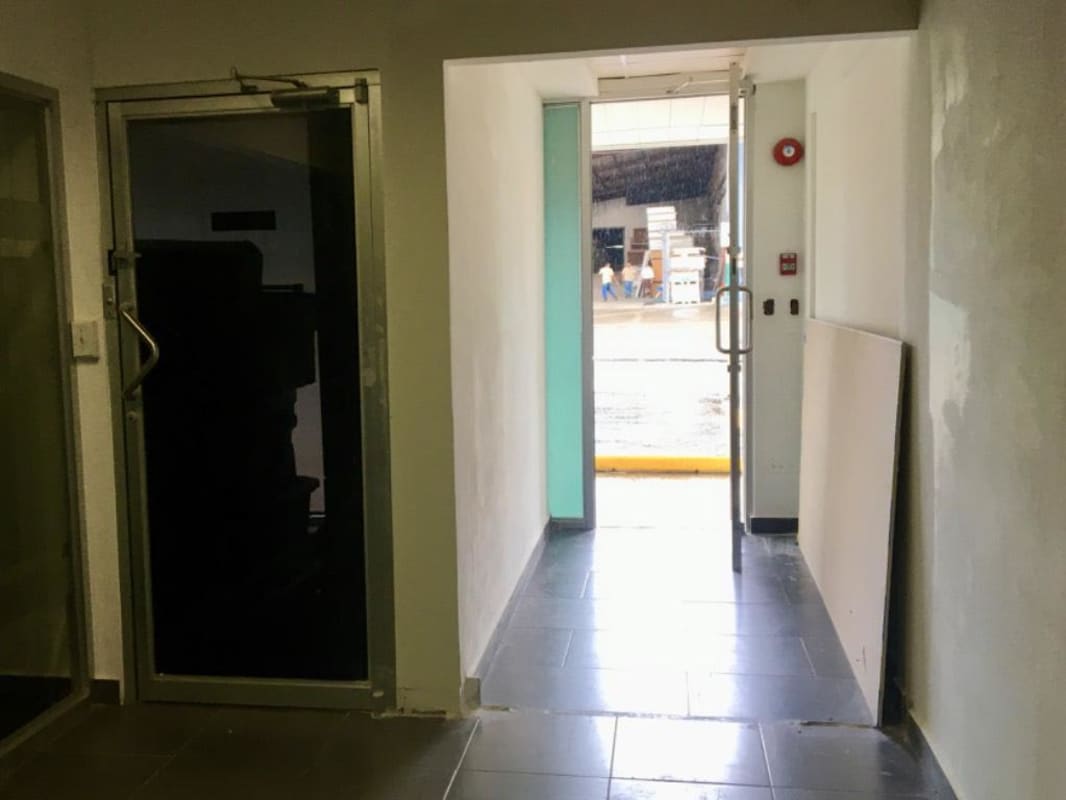 Interior corridor with glass doors leading to exterior in Plaza Clayton Panama commercial complex