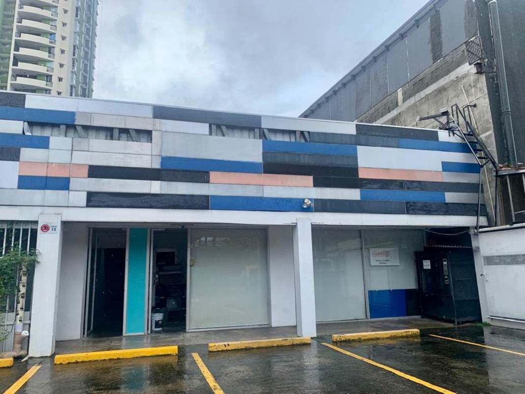 Strip mall style facade with glass windows and adjacent parking spaces Plaza Clayton Panama