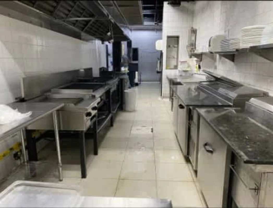Stainless steel commercial kitchen with appliances and ventilation at Ocean Drive Costa del Este Panama