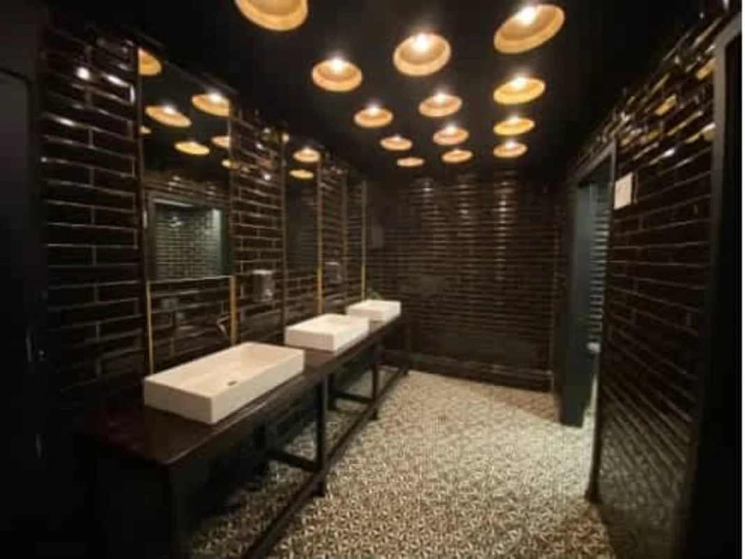 Industrial style bathroom with black tiles, double sinks at Ocean Drive Costa del Este Panama