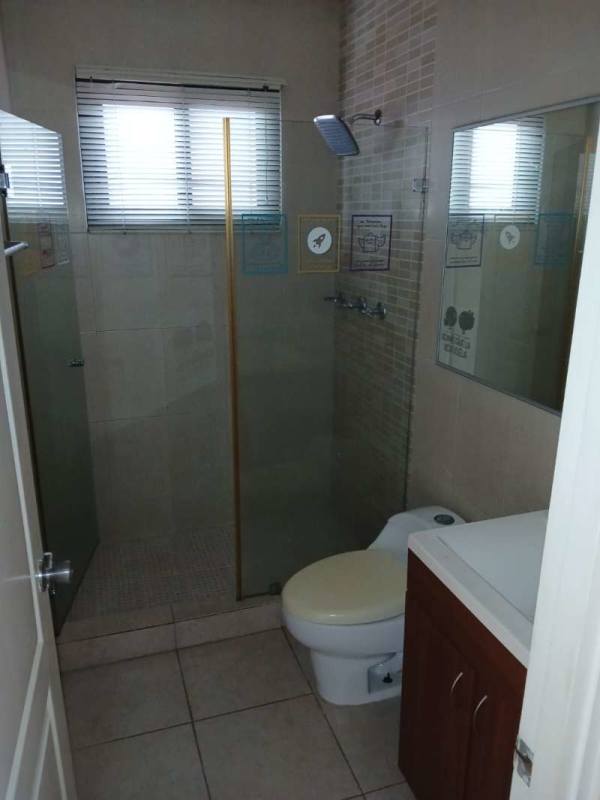 Modern bathroom with glass shower, tile finishes and vanity in Versalles gated community