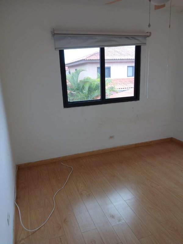 Bright bedroom with wood floors, large window and neighborhood view in Versalles Panama