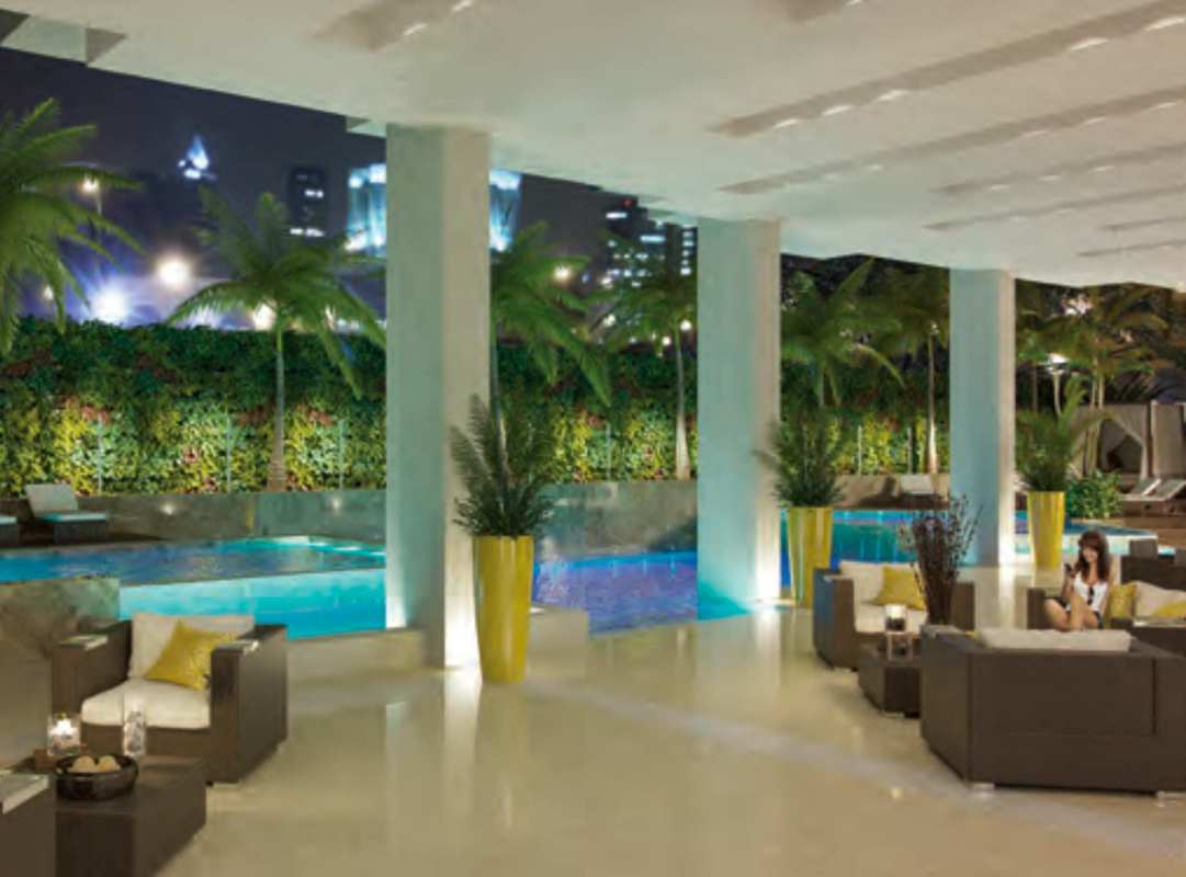 Swimming pool area with city skyline at night PH El Cangrejo Panama