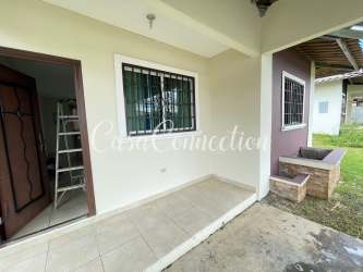 Spacious living and dining area with tiled flooring and sectional sofa in duplex house David Panama