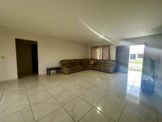 Spacious living area with ceramic tiled floor and large window in David Chiriquí house