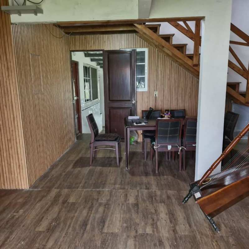 Dining space with wooden staircase, wood wall paneling, rustic design at Cerro Azul country estate Panama