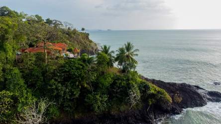 Open living and dining area with ocean views and large windows at private peninsula villa Mariatos Panama