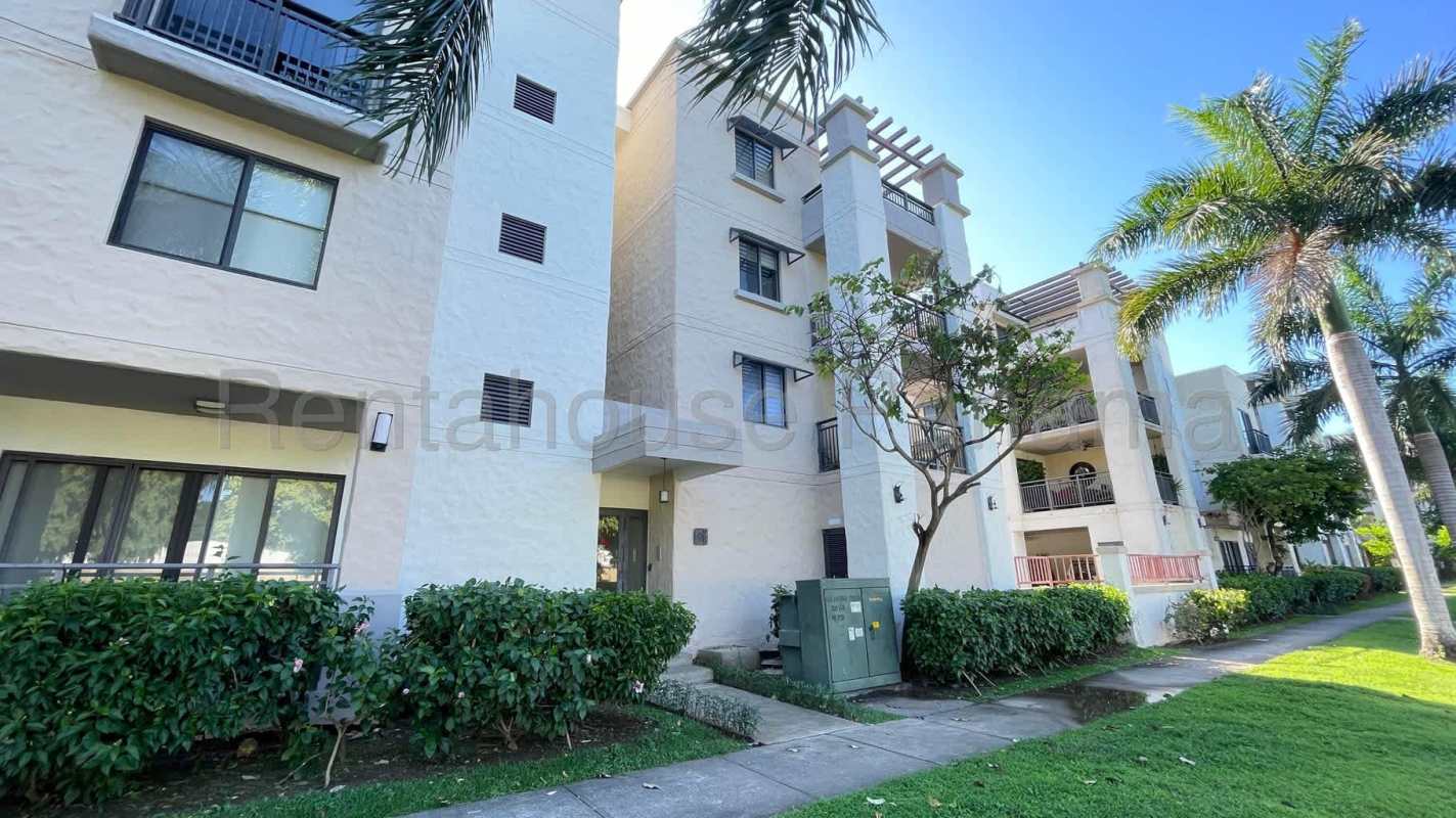 Community swimming pool surrounded by palm trees in River Valley Panama Pacifico apartments