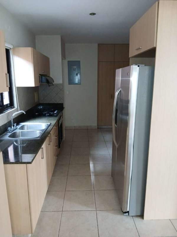 Contemporary kitchen with granite countertops, double sink and stainless steel appliances in Versalles Costa Sur Panama