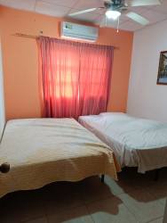 Bedroom with twin beds, AC, orange wall, Penonomé Panama