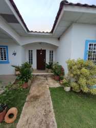 Arched doorway, blue window frames, garden Penonomé Llano Marín