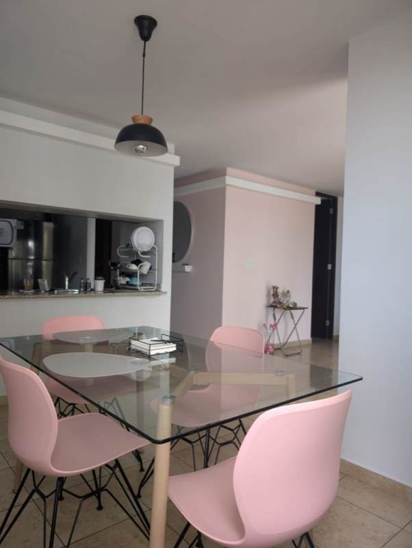 Open living dining room with gray sofa pink chairs balcony view in PH Torres de Transistmica Panama